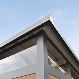 Modern architectural detail of a building's roofline with glass panels against a clear blue sky. Top View